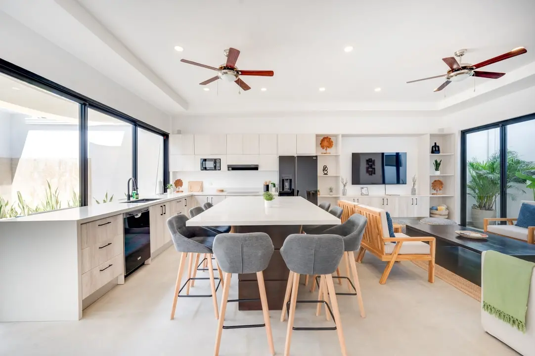 Tamawalk kitchen and dining area, featuring a spacious island with modern chairs and state-of-the-art appliances.