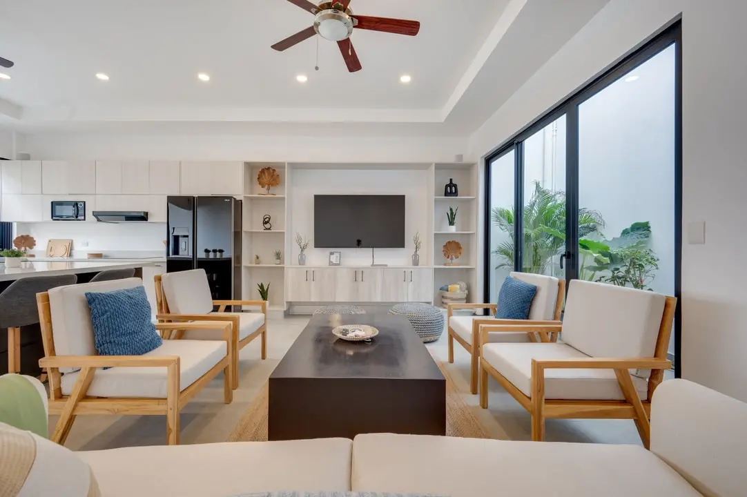 Tamawalk's bright living room features elegant furnishings, ceiling fans, and large windows that connect with nature.