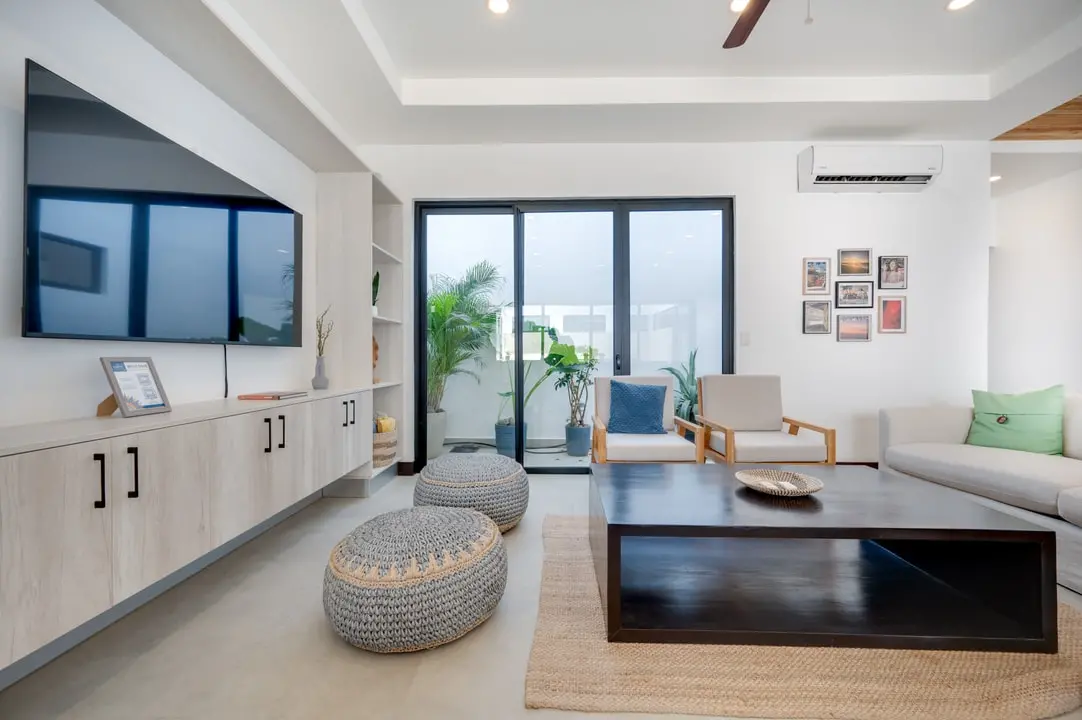 Tamawalk's living room features cozy light-wood furniture, large windows overlooking the garden, and natural details.