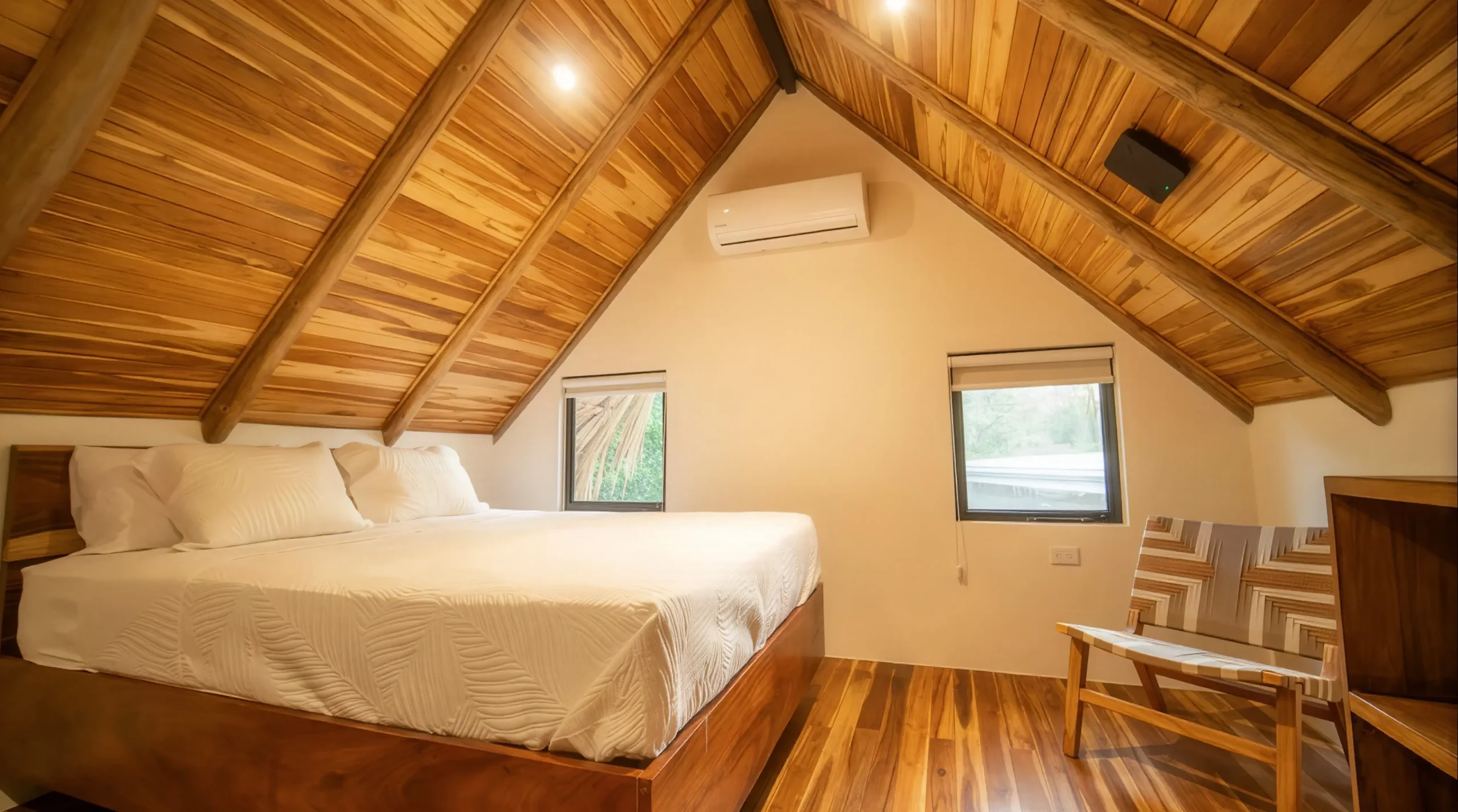 Charming bedroom in House Corona's guesthouse, featuring a cozy wooden bed, soft lighting, and natural details.