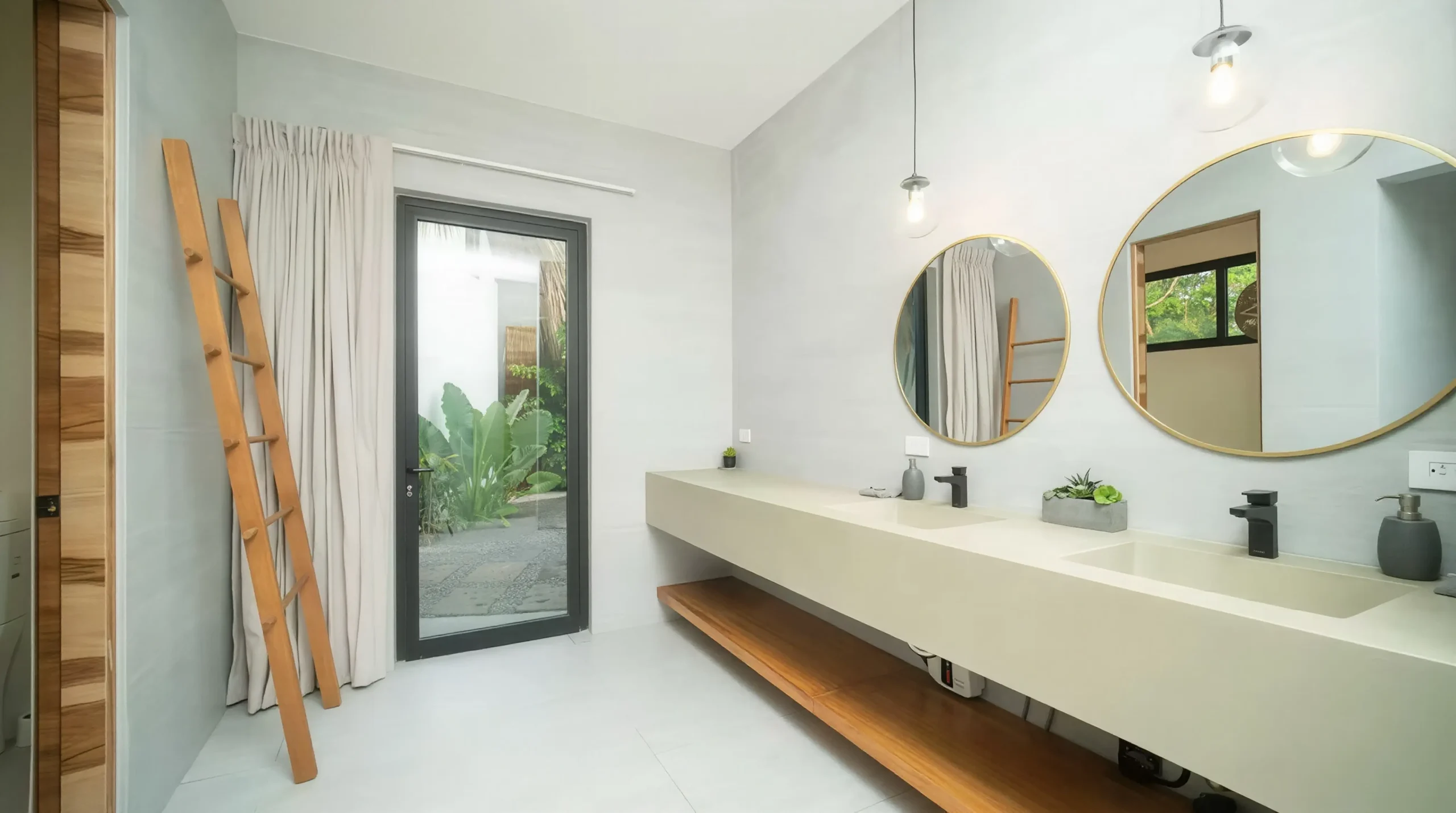 House Corona's contemporary bathroom features a clean-lined double sink, round mirrors, and a door that opens to an internal terrace.
